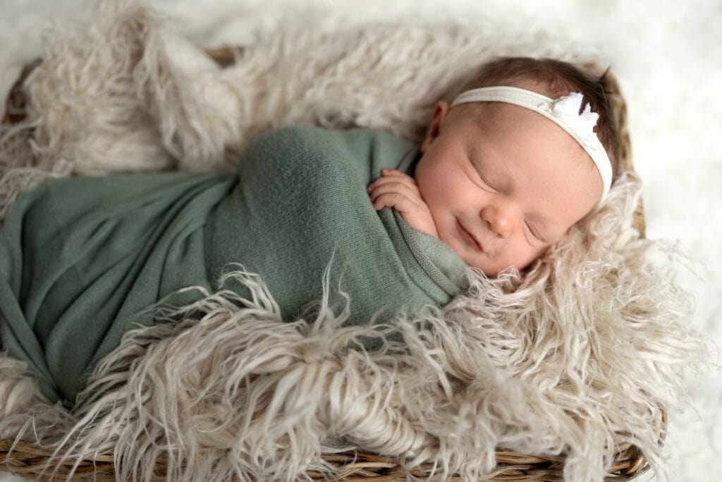 Baby girl asleep in newborn-safe basket