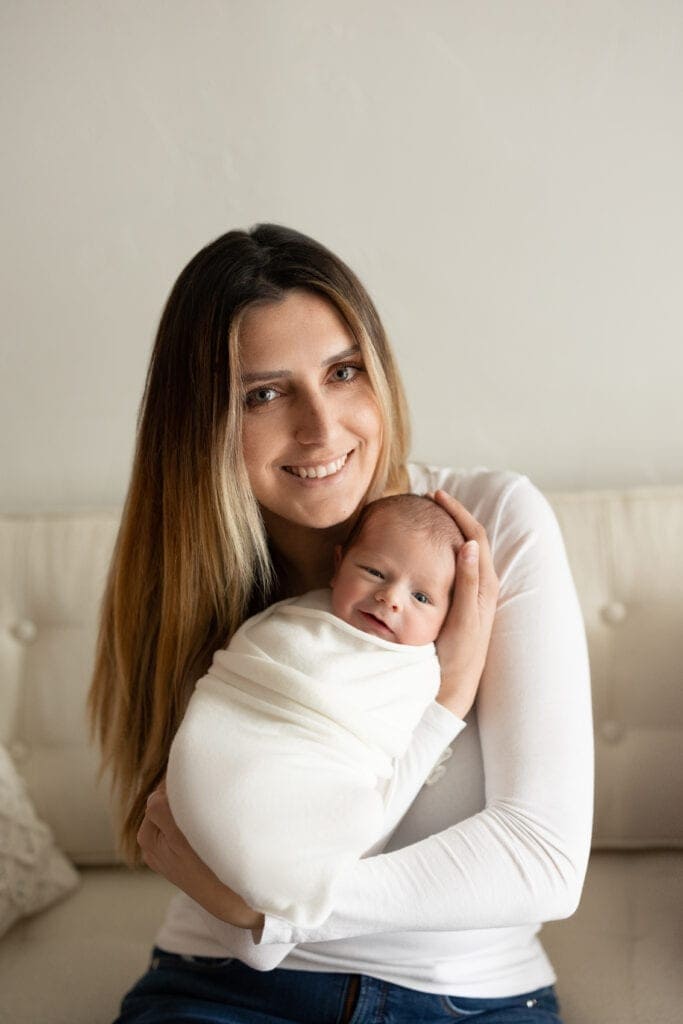 Mom holding swaddled infant for newborn photography in Colorado Springs