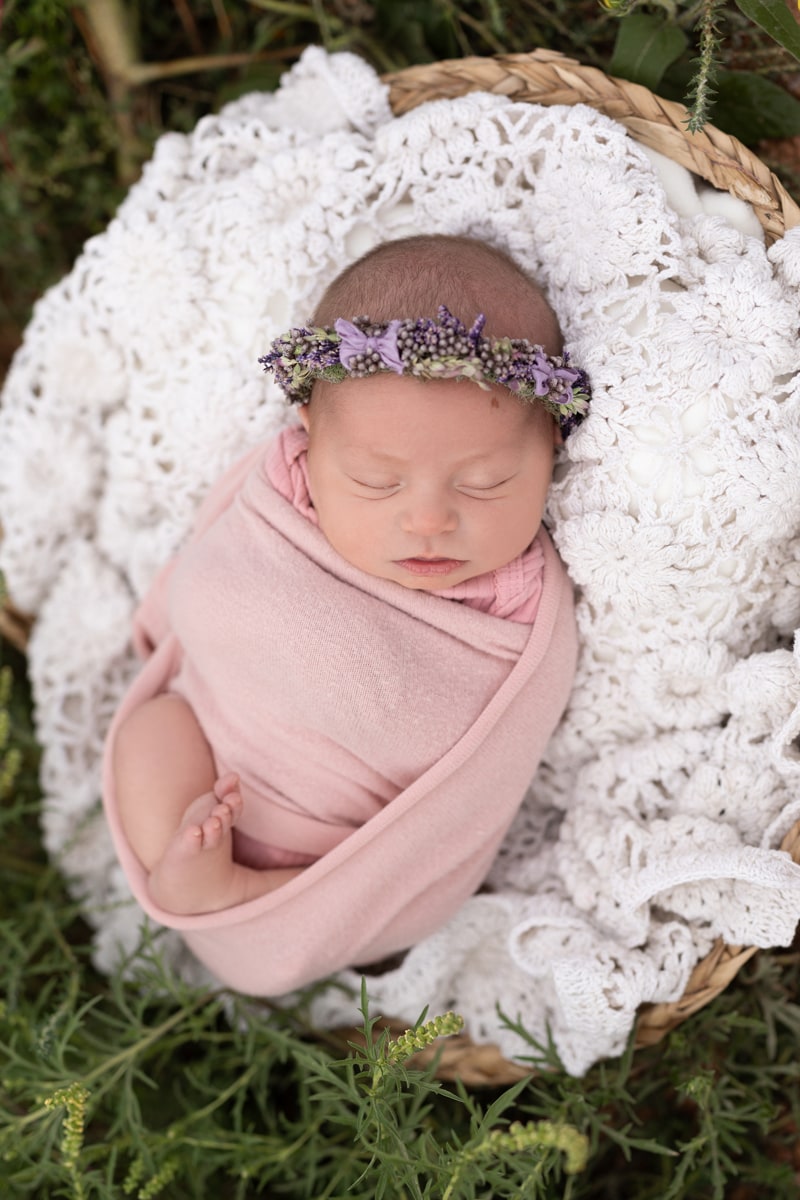 Newborn Photography, baby girl wrapped up in pink swaddle with flower headband