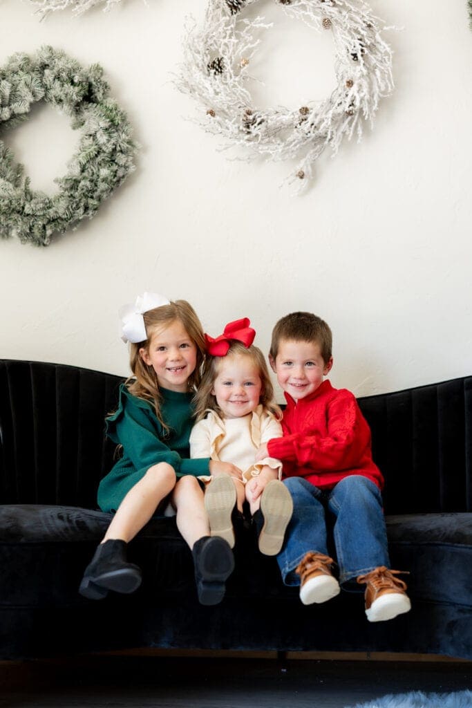 Siblings seated on couch during holiday mini sessions in Colorado Springs