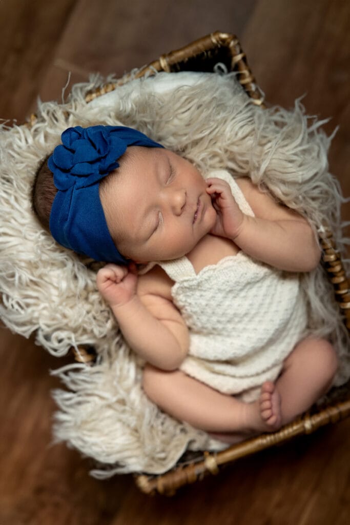 Infant girl in blue bow fast asleep 