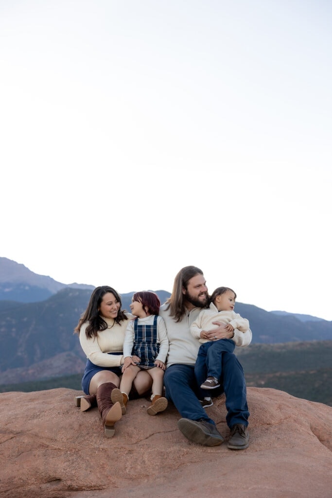 Family seated on rock formation in Garden of the Gods
