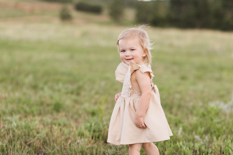 Family Photography, Little girl standing in field, looking at the camera