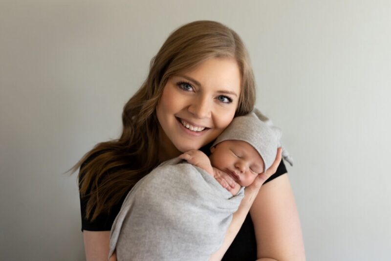Mother supporting baby's head while she cradles him during a lifestyle newborn photography session in Colorado Springs